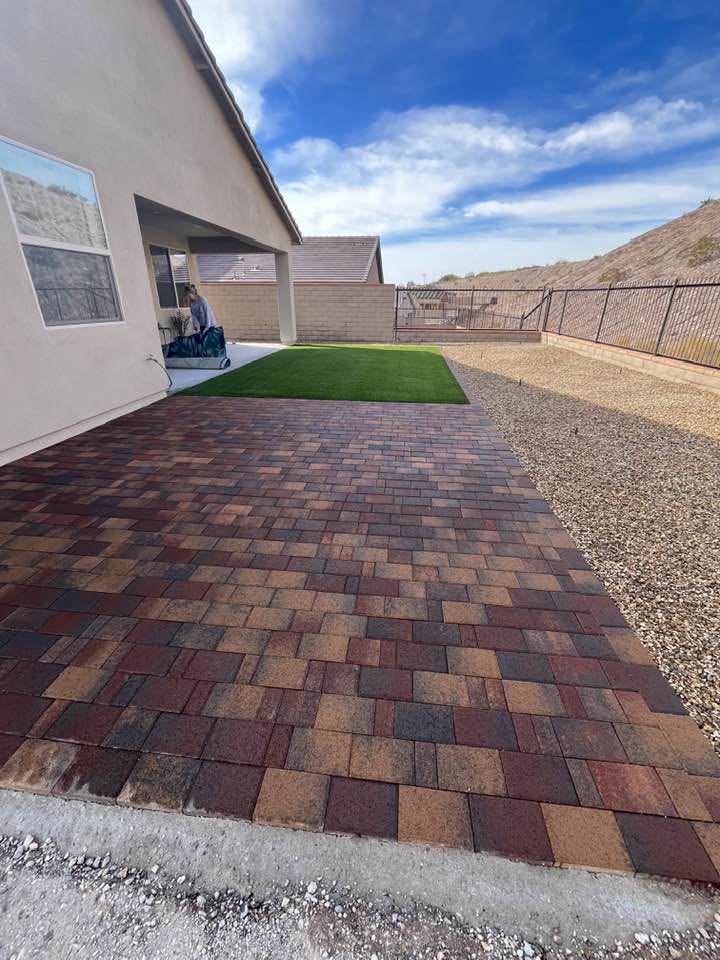 Backyard finished with brick pavers, turf and decorative rock