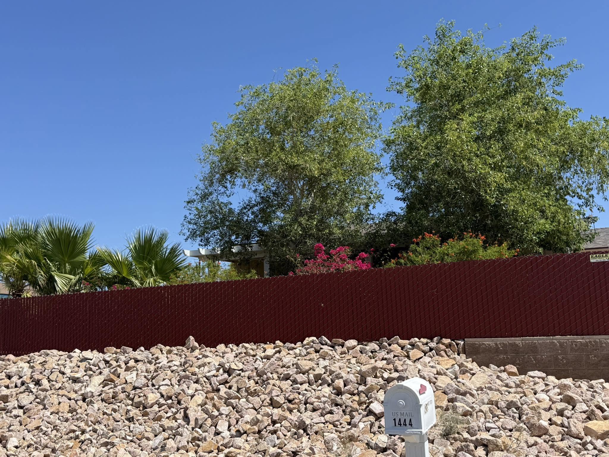Red chain-link privacy fence installed by Eagle Masonry and Fence